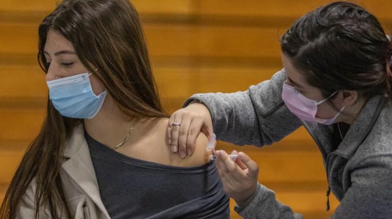 A College of 整骨疗法的医学 students gives a vaccine to another student at the Vaccine Clinic